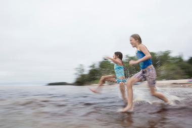 Two girls running into Lake Winnipeg